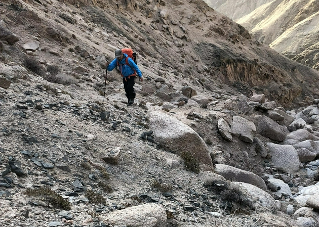 邓李才爬山。jpg 道路还没有修达选址点。上山维护、更新设备需要从山脚越野车能到的地方攀登到4200米海拔的山顶，6公里的行程，近一千米的高差外加10公斤左右的物资和给养，还是一个非常挑战的任务。这是2018年初冬邓李才在登山途中，田才让拍摄。